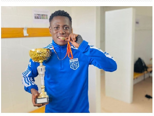 Listowell Agyemang Duah shows off the trophy after scoring the winning penalty