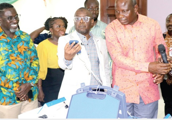 Alhaji Hafiz Adam (2nd from right) examining one of the devices
