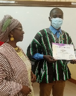 Prof Abena Busia presenting a certificate to a member of the team