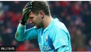 Bochum goalkeeper Patrick Drewes grabs his head after being hit by an object thrown from the crowd
